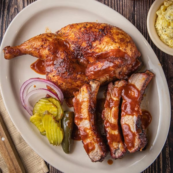 Luka's Barbecue & Steakhouse's BBQ chicken and ribs with pickles, onions, and jalapeños.